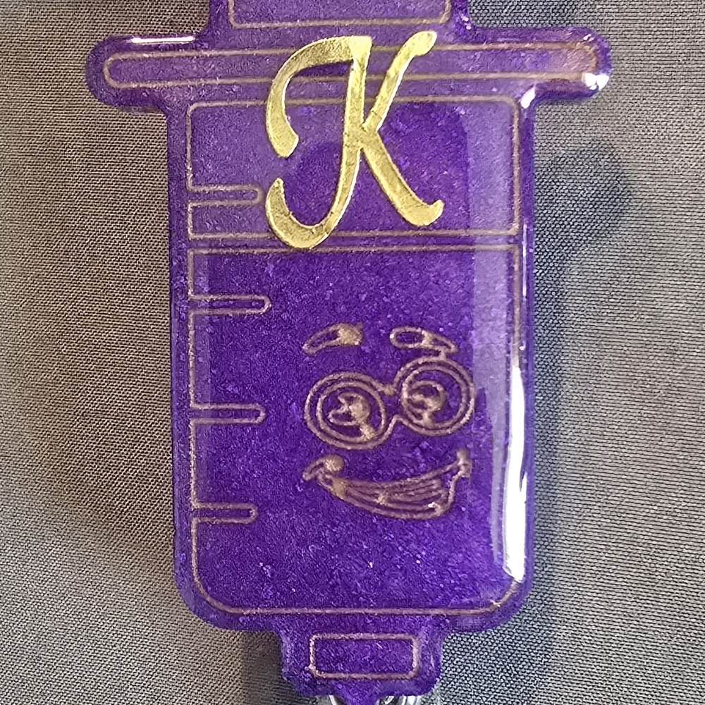 Purple Syringe-Shaped Badge Reel with Gold Letter K